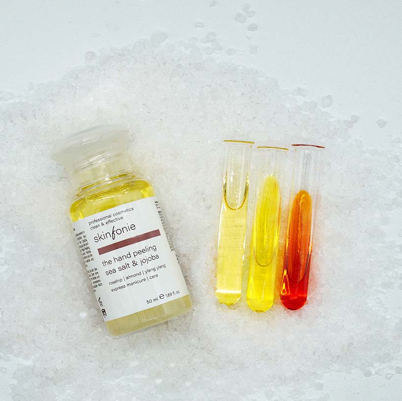 SKINFONIE the hand peeling sea salt & jojoba  – 50ml, Spender und Reagenzgläser auf Salz liegend