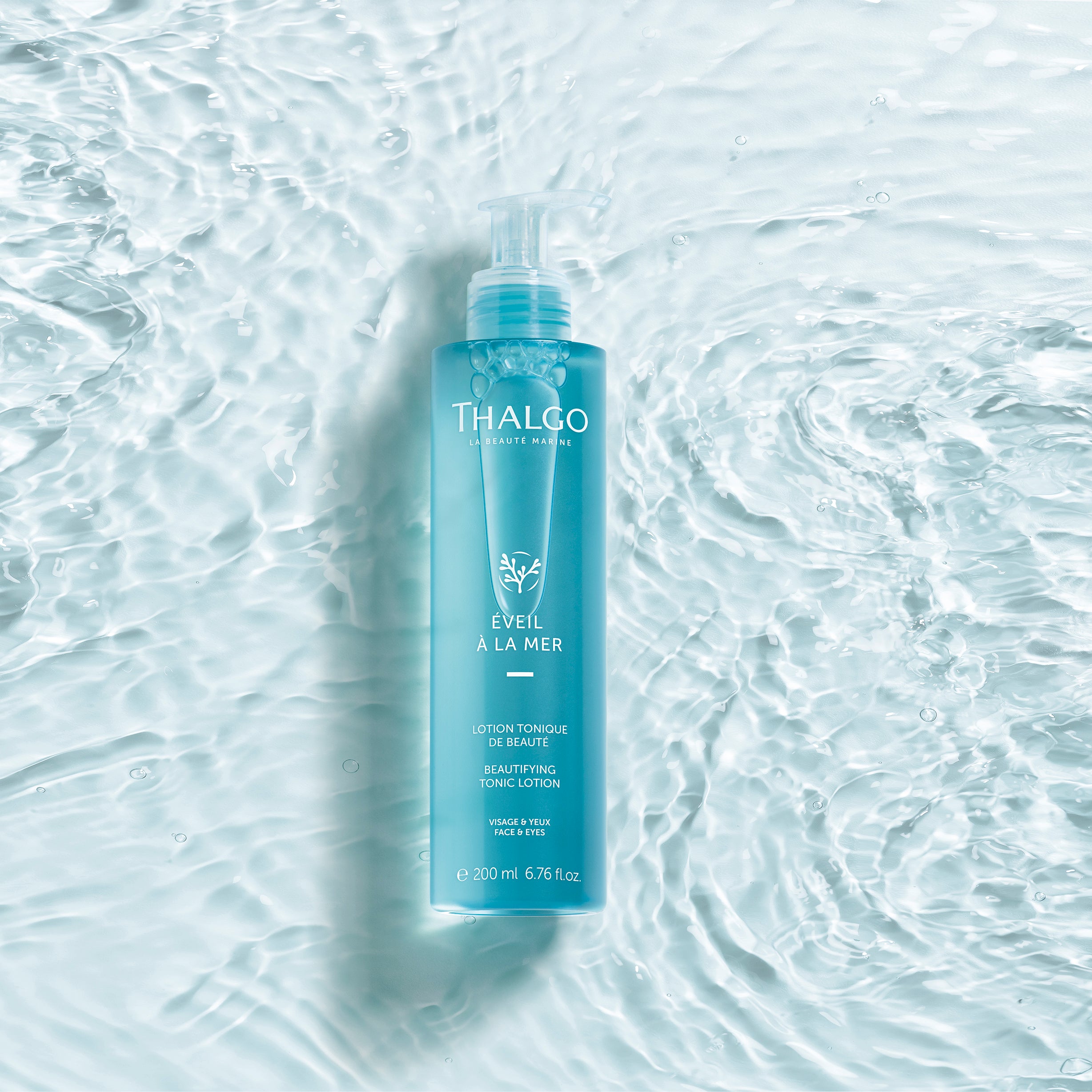 THALGO Éveil à la Mer - Meerwasser Tonic – 200ml, Pumpspender liegend mit Wasser als Hintergrund