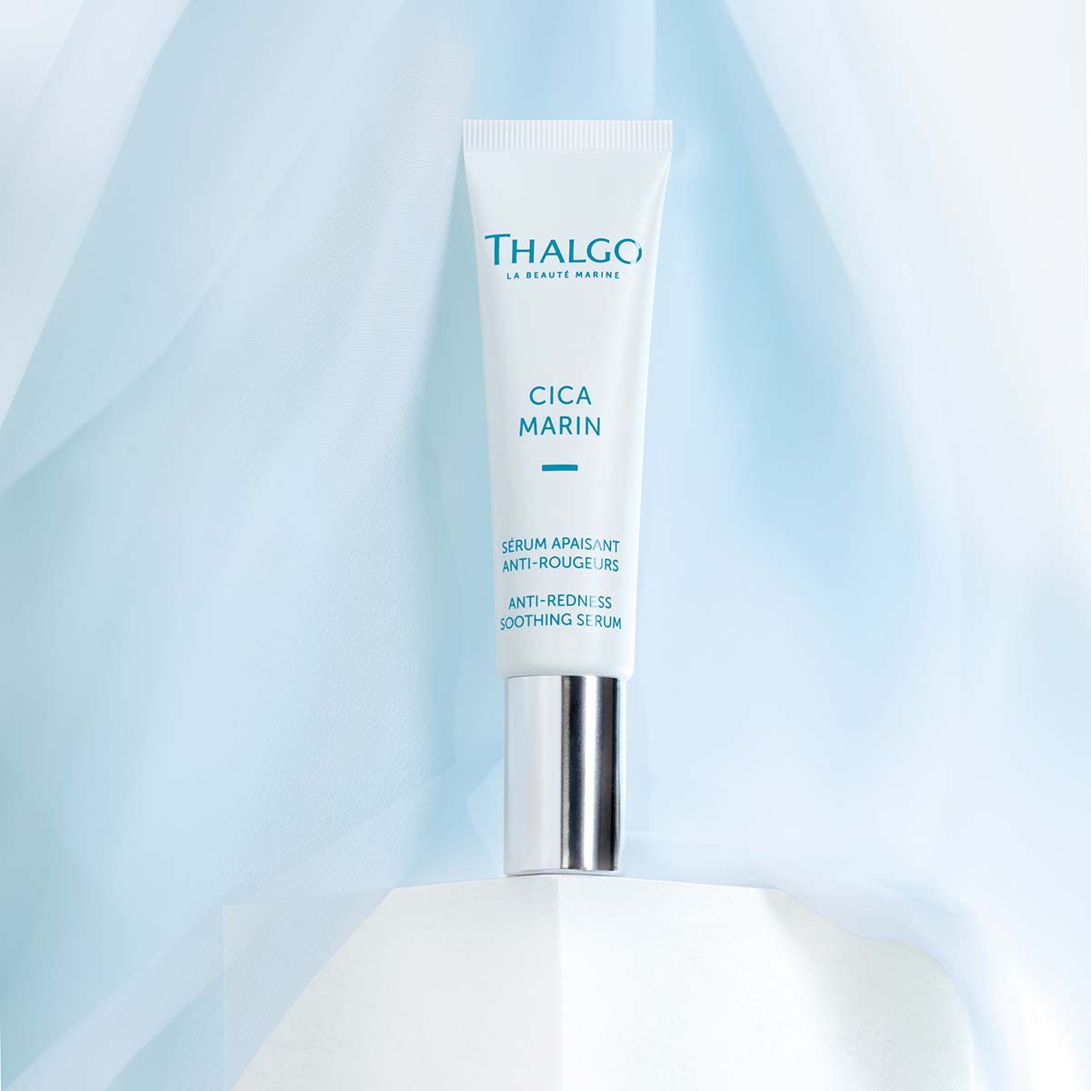 THALGO CICA MARIN Beruhigendes Serum gegen Rötungen  – 30ml, Tube stehend vor blauer Stoffbahn