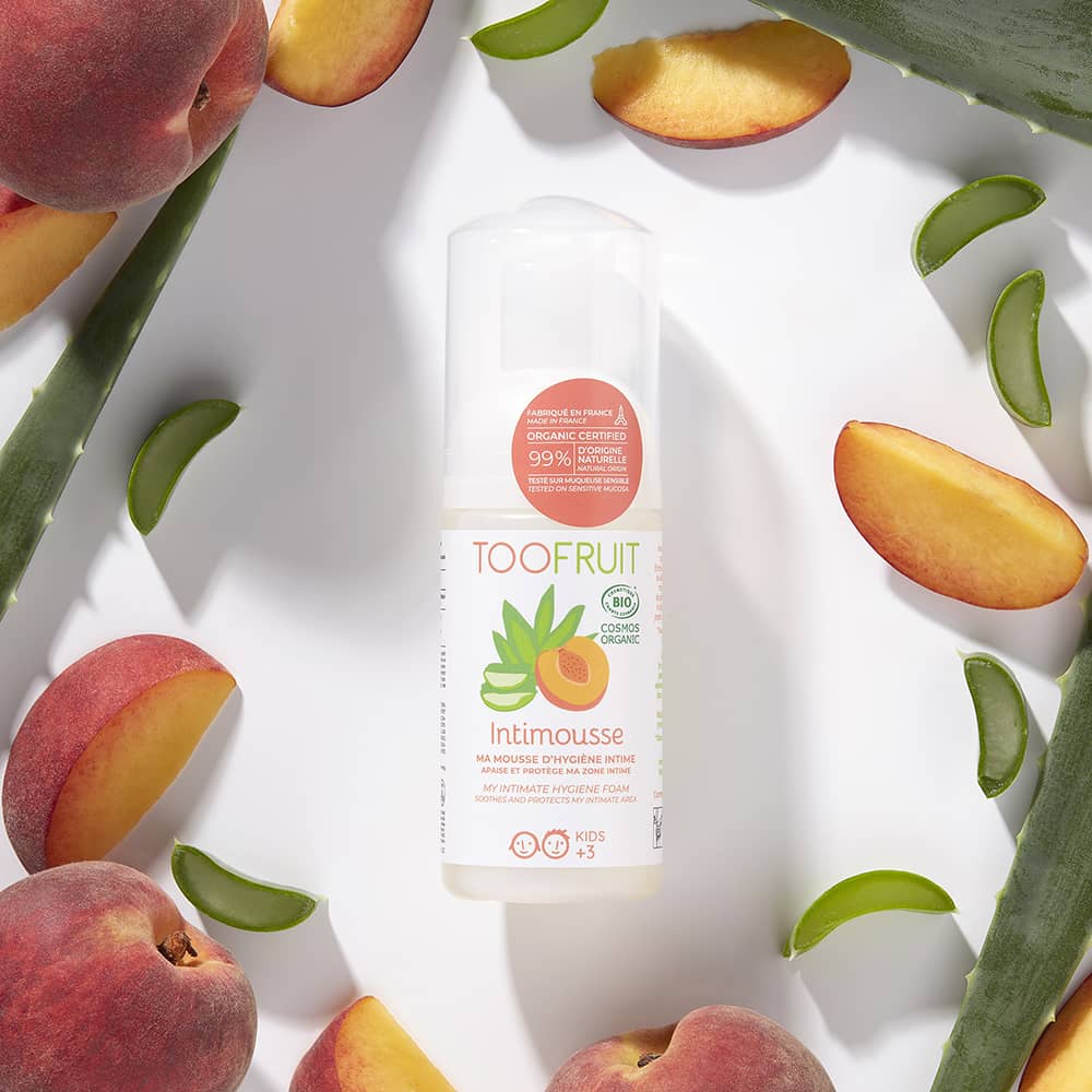 TOOFRUIT Intimschaum  – Aloe Vera - Pfirsich, 100ml, Schaumspender umringt von Aloe Vera Blättern und Pfirsichen